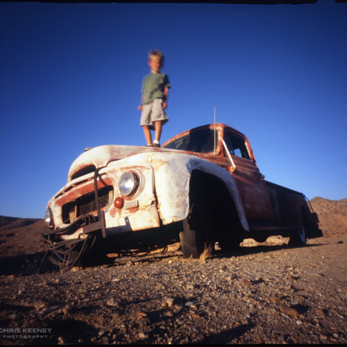Zero Image 6x6 camera photo of young boy standing on hood of old rusty truck