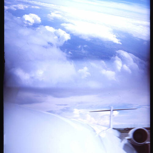 Vertical Holga camera color photo of jet airplane and clouds
