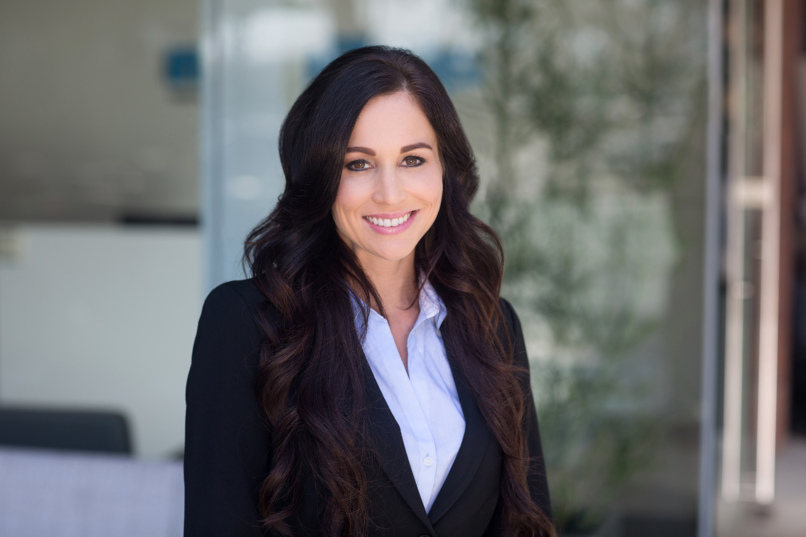 Professional lifestyle headshot portrait photograph of Newport Beach business woman standing out front of company office building