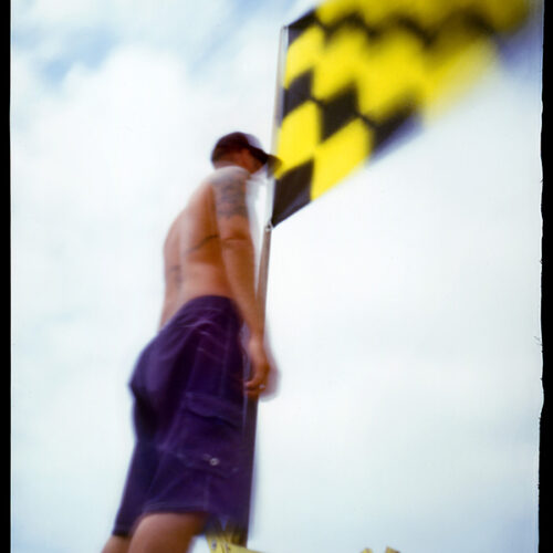 6x7 Ansco Pinhole photograph of man standing next to surf flag at La Jolla Shore beach