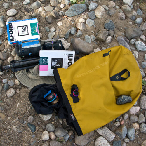 Homemade pinhole camera field kit backpack which includes small tripod, MexiCanon pinhole camera, Coffee can pinhole camera, Ilford 5x7 photographic paper for negatives; film changing bag and yellow top loading Dana Designs backpack