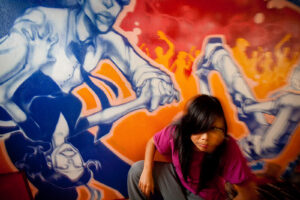Hip hop dancer in front of colorful mural at Culture Shock dance school