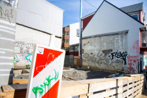 colorful angular photograph of a construction site in a neighborhood in Reykjavík Iceland with orange and white street signs and painted graffiti art on the walls in the background