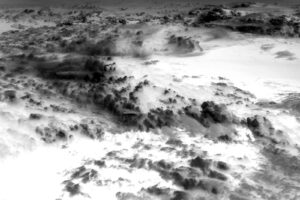 black and white photo of clouds inverted so that it changes the way you perceive clouds. Now that the negative areas are positive and the positive areas are negative they don't look like clouds but more like mountains with snow in the valleys below.
