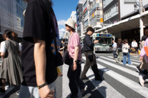 A photo of people crossing the street in a crosswalk in downtown Kyoto Japan