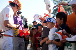 young professional golfer, Rickie Fowler signing orange Puma golf towels for young children and fans at the Farmers Insurance open at Torrey Pines in La Jolla