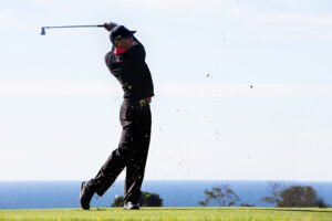 color photograph of professional golfer, Tiger Woods just after he hit the ball teeing off with an iron at the 2013 Farmers Insurance Open at Torrey Pines Golf Course, in La Jolla, San Diego, California