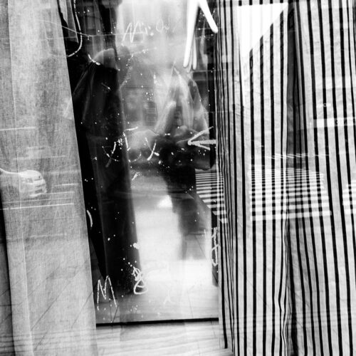 abstract black and white photo of a reflection of Chris Keeney in a store window in downtown Tokyo Japan