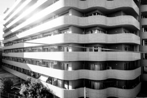 Black and white photograph of an apartment building with multiple levels and balconies, windows and doors in Osaka Japan