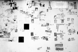 Black and white photograph of the sticky residue of tape left behind after a sticker has been removed from a wall on the streets of Tokyo Japan. A random but pleasing geometric graphic design is left behind.
